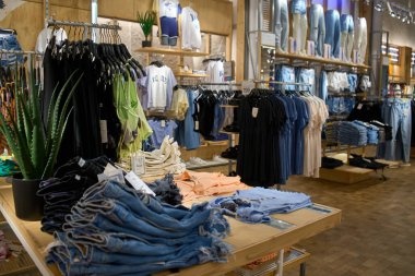 Ukrayna, Dnipropetrovsk. Giysi mağazasında askıda asılı 05.06.2021 kot pantolon ya da Denim pantolonu. Moda ürün koleksiyonu satış için giyim mağazasında. Tekstil endüstrisi. Mavi kot pantolon.