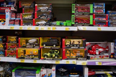 Ukrayna, Dnepropetrovsk.05.06.2021 Rafı birçok renkli oyuncakla. Çocuk oyuncakçılarının geçmişi bulanık. Bir mağazadaki raflarda çeşitli inşaat oyuncakları. Çocuk mağazasındaki oyuncak renkli plastik arabalar.