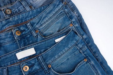 Beyaz arka planda kot pantolon desenli mavi kot pantolonların çeşitli tonlarında. Tasarım için Denim arkaplan dokusu. Kumaş kumaş. Arkaplan olarak kullanılabilen mavi kot.