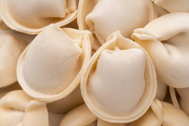 Beyaz arka planda izole edilmiş, pişirilmeye hazır taze donmuş hamur köfteleri. Tam alan derinliği.