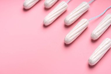 Pembe arka planda tıbbi kadın tamponu. Kadınlar için hijyenik beyaz tampon. Pamuklu çubuk. Regl, korunma aracı. Kırmızı arkaplanda tamponlar.