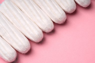 Pembe arka planda tıbbi kadın tamponu. Kadınlar için hijyenik beyaz tampon. Pamuklu çubuk. Regl, korunma aracı. Kırmızı arkaplanda tamponlar.