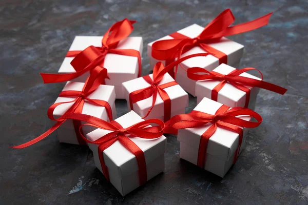 White gift box with red ribbon bow. Christmas gifts presents. Simple, classic red and white wrapped gift boxes with ribbon bows. Merry Christmas. Happy New Year.