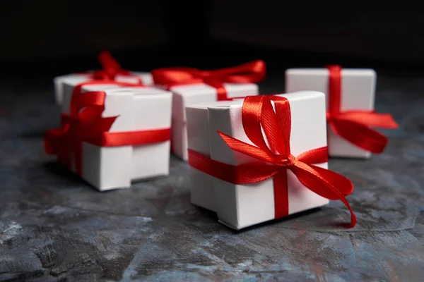 White gift box with red ribbon bow. Christmas gifts presents. Simple, classic red and white wrapped gift boxes with ribbon bows. Merry Christmas. Happy New Year.
