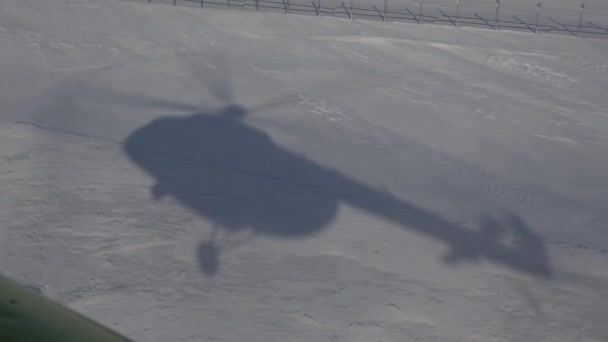 Skyggen av et helikopter i snøen. – stockvideo