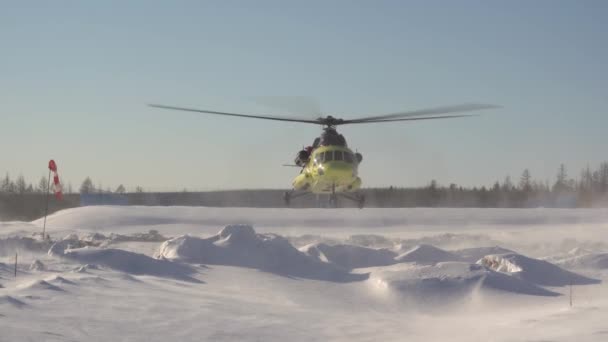 O helicóptero descola. O Mi-8 descola em nuvens de neve. Pó de neve durante a decolagem. — Vídeo de Stock