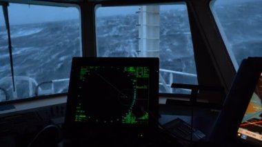 Fırtınada bir gemi. Radar ve kontrol paneli. Köprü. İyi atıştı. Yüksek dalgalar gemiyi vurur. Suda beyaz köpük.