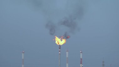 Benzin yanığı. Büyük bir alev. Kara duman. Meşale. Petrol ve gaz sahası.