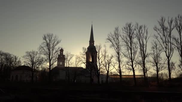 대성당 과 태양등 불빛. 교회를 통과하는 햇살. 태양 이 종탑을 통과하고. 실루엣. 좋은 아침. 나뭇잎 이 없는 나무 — 비디오