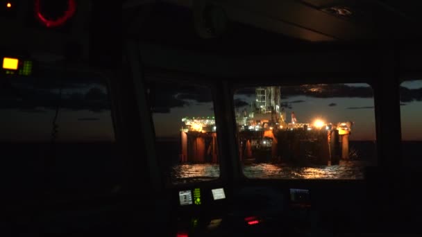 Bohren Offshore-Plattform in Lichtern. Blick aus dem Fenster der Schiffsbrücke. — Stockvideo