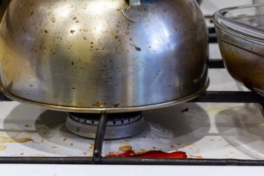 Pişirme sırasında kirli gaz sobası lekeli, yağlı bir soba. Evin dağınıklığı.