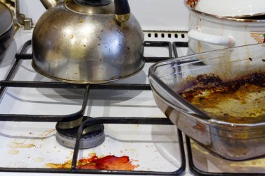 Pişirme sırasında kirli gaz sobası lekeli, yağlı bir soba. Evin dağınıklığı.