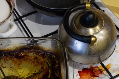 Kirli gaz ocağı. Pişirdikten sonra fırın. Mutfakta bir karışıklık var..