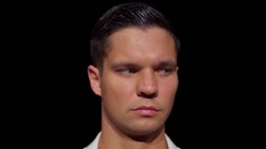 Çekici genç adamın yüzüne yakın çekim, sağdan sola doğru endişeyle izleyen, karanlıkta dans eden kadının zar zor fark edilebilen figürü. Sezgi anlayışı, mevcudiyet hissi.