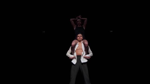 Ženská tanečnice sedí na mužských ramenou, pohybují se synchronní s zakřivenými pažemi jako v orientálním tance, ukazují plasticitu ruky, žena dělá převrat dolů.. — Stock video