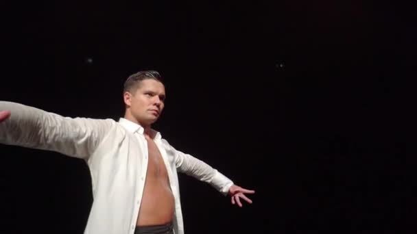 Close-up of male dancer taking woman from flip upside down,lifting her into dance support on shoulders from behind,rotating in beautiful pose.Slightly accelerated video of dancers pair on dark stage — Stock Video