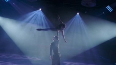 Artistik patinajcılar sabit pervane kaldırma yapıyorlar. Erkek, kadını tek eliyle havada döndürür. Kolları ve bacakları açıktır. Yasak destek, yavaş çekim, yakın çekim..