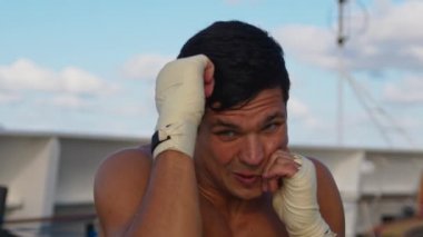 Çekici ve güçlü genç adam, dışarıda, yolcu gemisinde gölge boksu yaparak kutu egzersizi yapıyor.