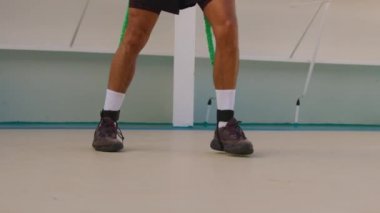 Legs movement of strong man practice shadow boxing with outdoors resistance band training strap system outdoors