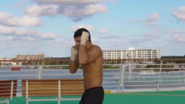 Cozumel Meksika arka plan görüşlü, helikopter pistinde çıplak gövde egzersiz kutusu olan genç ve güçlü bir adam.