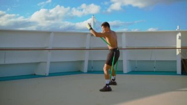 Boksör boks antrenmanı yapıyor ve direnç bandı eğitim sistemi ile gölge boksu yapıyor