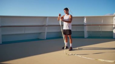 Beyaz tişörtlü atletik çekici adam boks antrenmanına başlamak için sargılarını sarar. 