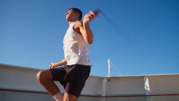 Сильний молодий спортивний чоловік стрибає мотузкою надворі — стокове відео