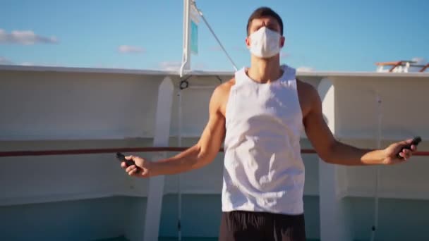 Handsome young man in face mask jumps on rope outdoor — Stock video