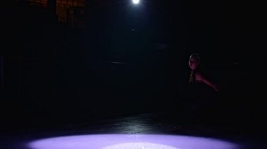 Ice skater gorgeous girl on a dark ice rink figure skating elements