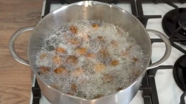 Kabuklu büyük bahçe salyangozları restoran mutfağındaki bir tencerede kaynar suda kaynatılır. Sağlıklı yemek pişirme kavramı. Avrupa, Fransız mutfağı. Yakın plan. İnsanlar olmadan. 4K