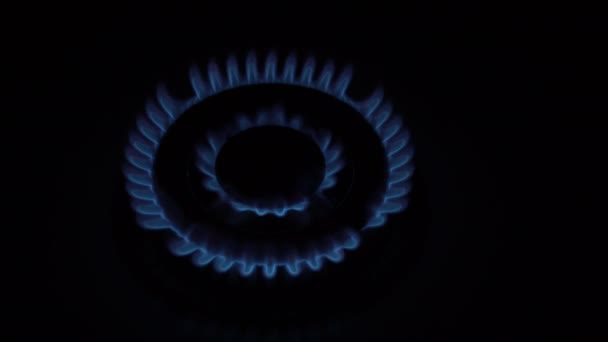 Primo piano, il bruciatore a gas brucia e si spegne lentamente sulla cucina casa stufa a gas su uno sfondo nero. Il concetto di crisi energetica. Interruzione delle forniture di gas. Senza persone. Vista dall'alto. 4K. — Video Stock