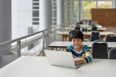 Laptop Bilgisayarı, Öğrenme ve Kullanma Bilgisayar Konsepti ile oynayan Asyalı şirin çocuğun portresi