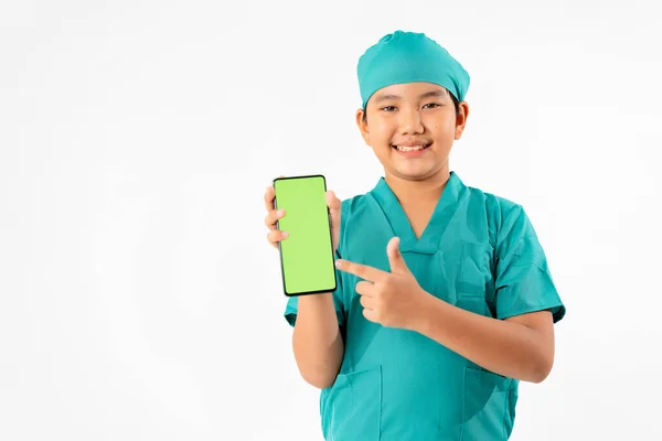 博士になるための若いアジアの少年のドレッシングの肖像 白の背景に緑の画面の隔離とスマートフォンを保持 教育と技術の概念 — ストック写真