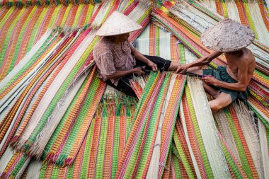 Vietnamlı yaşlı adam ve kadınlar geleneksel Vietnam hasırlarını kurutuyorlar. Geleneksel köyde dinh yen, dong thap, Vietnam, gelenek sanatçısı konsepti, Vietnam.