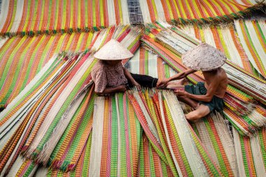 Vietnamlı yaşlı adam ve kadınlar geleneksel Vietnam hasırlarını kurutuyorlar. Geleneksel köyde dinh yen, dong thap, Vietnam, gelenek sanatçısı konsepti, Vietnam.