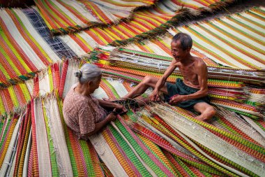 Vietnamlı yaşlı adam ve kadınlar geleneksel Vietnam hasırlarını kurutuyorlar. Geleneksel köyde dinh yen, dong thap, Vietnam, gelenek sanatçısı konsepti, Vietnam.