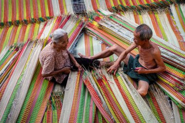 Vietnamlı yaşlı adam ve kadınlar geleneksel Vietnam hasırlarını kurutuyorlar. Geleneksel köyde dinh yen, dong thap, Vietnam, gelenek sanatçısı konsepti, Vietnam.
