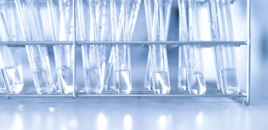 Mavi arka planda moleküler yapısı olan kimyasal bilim eğitim laboratuvarında cam matara.