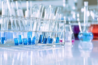 Mavi arka planda moleküler yapısı olan kimyasal bilim eğitim laboratuvarında cam matara.