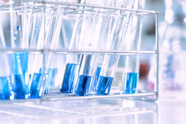 Mavi arka planda moleküler yapısı olan kimyasal bilim eğitim laboratuvarında cam matara.