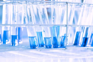 Mavi arka planda moleküler yapısı olan kimyasal bilim eğitim laboratuvarında cam matara.