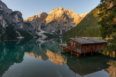 Amazing Sunrise view of Lago di Braies (Pragser Wildsee) with Wooden boats, one of the most beautiful lake in South Tirol, Dolomites mountains, Italy. Popular tourist attraction.