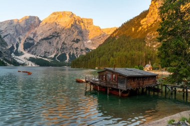 Amazing Sunrise view of Lago di Braies (Pragser Wildsee) with Wooden boats, one of the most beautiful lake in South Tirol, Dolomites mountains, Italy. Popular tourist attraction.