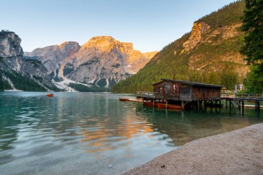 Amazing Sunrise view of Lago di Braies (Pragser Wildsee) with Wooden boats, one of the most beautiful lake in South Tirol, Dolomites mountains, Italy. Popular tourist attraction.