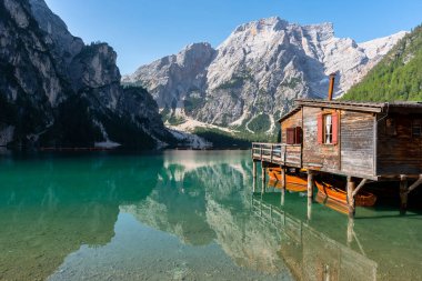 Amazing Sunrise view of Lago di Braies (Pragser Wildsee) with Wooden boats, one of the most beautiful lake in South Tirol, Dolomites mountains, Italy. Popular tourist attraction.