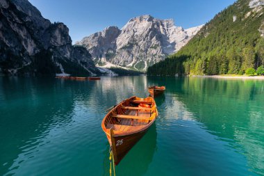 Amazing Sunrise view of Lago di Braies (Pragser Wildsee) with Wooden boats, one of the most beautiful lake in South Tirol, Dolomites mountains, Italy. Popular tourist attraction.