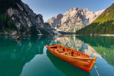 Amazing Sunrise view of Lago di Braies (Pragser Wildsee) with Wooden boats, one of the most beautiful lake in South Tirol, Dolomites mountains, Italy. Popular tourist attraction.