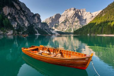 Amazing Sunrise view of Lago di Braies (Pragser Wildsee) with Wooden boats, one of the most beautiful lake in South Tirol, Dolomites mountains, Italy. Popular tourist attraction.