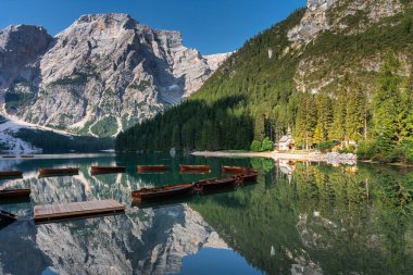 Amazing Sunrise view of Lago di Braies (Pragser Wildsee) with Wooden boats, one of the most beautiful lake in South Tirol, Dolomites mountains, Italy. Popular tourist attraction.