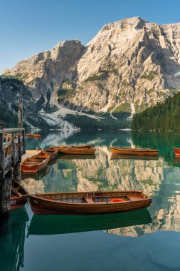 Amazing Sunrise view of Lago di Braies (Pragser Wildsee) with Wooden boats, one of the most beautiful lake in South Tirol, Dolomites mountains, Italy. Popular tourist attraction.